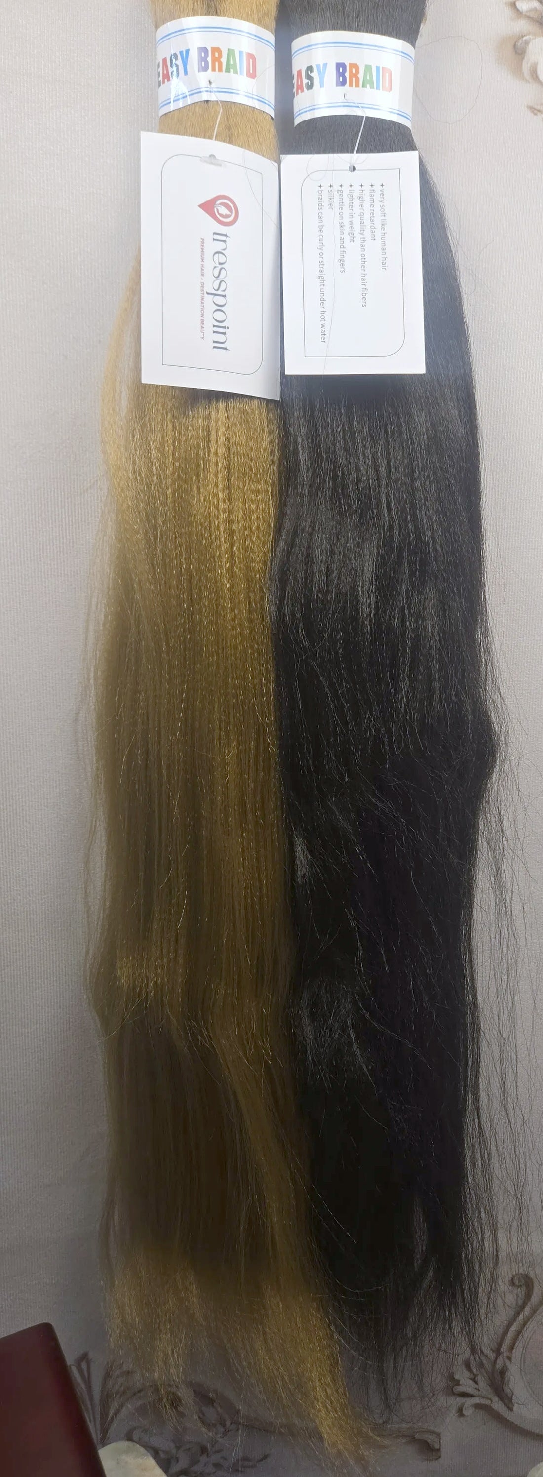 Tresspoint Kanekalon braiding hair in 27 honey blonde and 1B off black, shown full length with Tresspoint hang tags