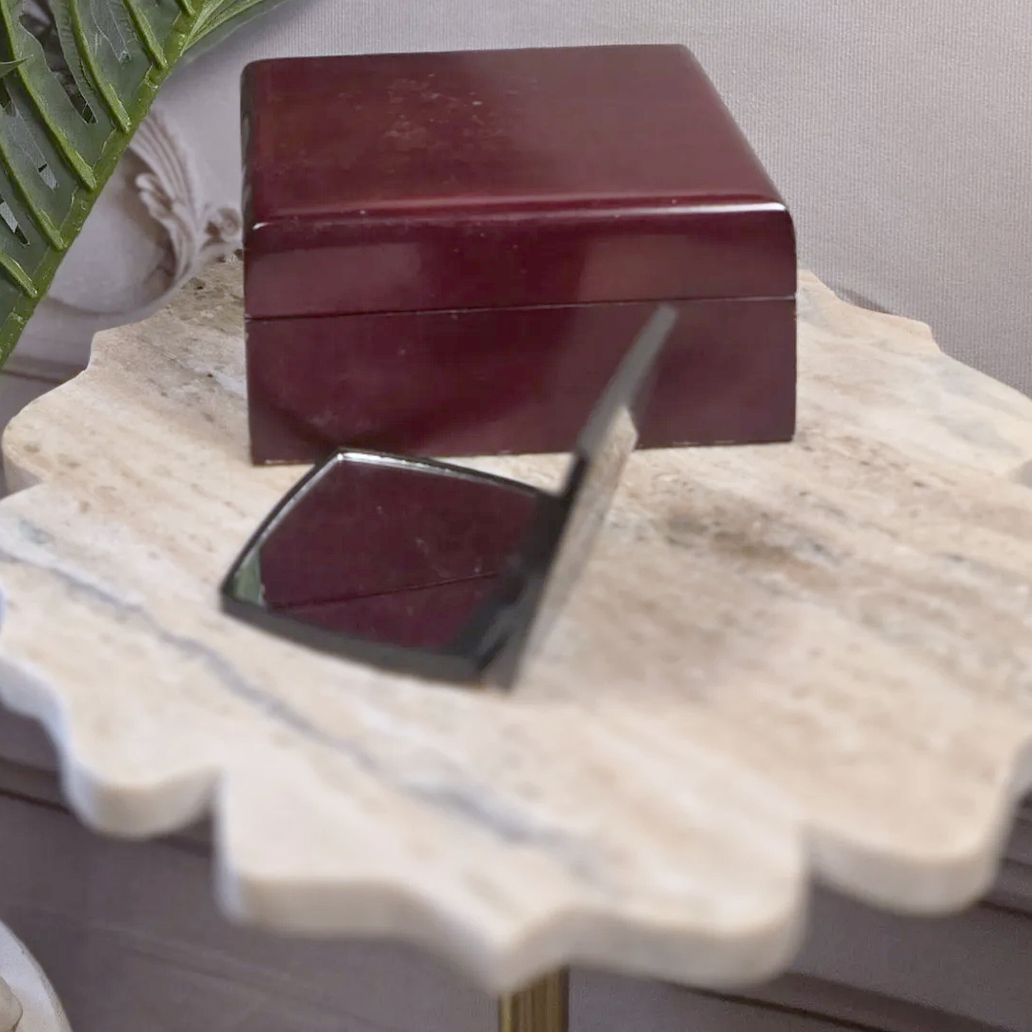 Tresspoint compact folding mirror styled on a stone table beside a burgundy jewelry box
