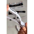 Tresspoint crease-free sectioning clip in white, held open to show the grip jaw for parting thick textured hair